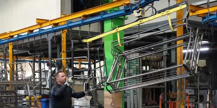 Distanziamento sociale in produzione industriale è possibile con un manipolatore Un operaio da solo può sollevare e spostare grandi telai di divano con l'aiuto di un manipolatore INDEVA