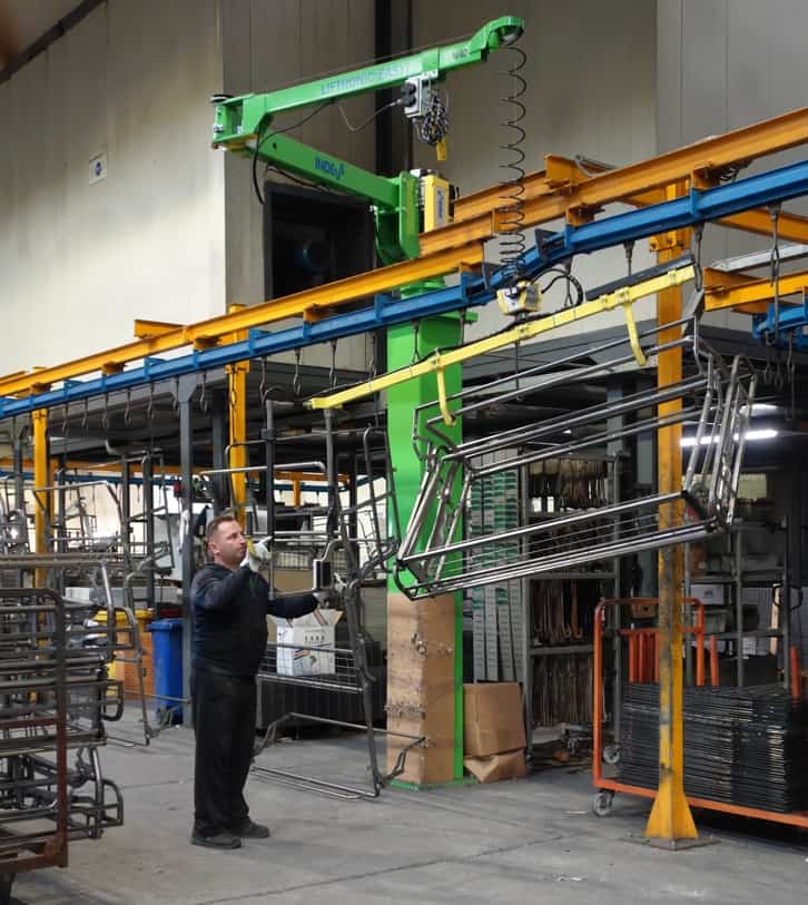 Distanziamento sociale in produzione industriale è possibile con un manipolatore Un operaio da solo può sollevare e spostare grandi telai di divano con l'aiuto di un manipolatore INDEVA